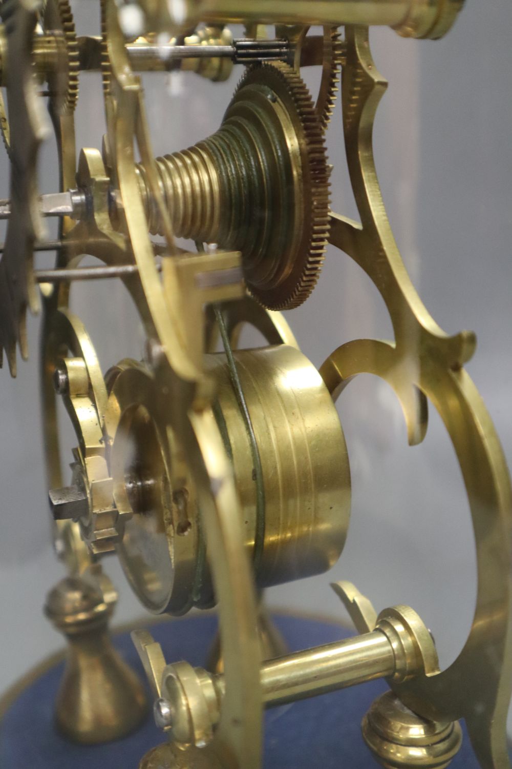 A 19th century brass skeleton clock, with fusee and in-line train, under glass dome, with key and pendulum, height 41cm